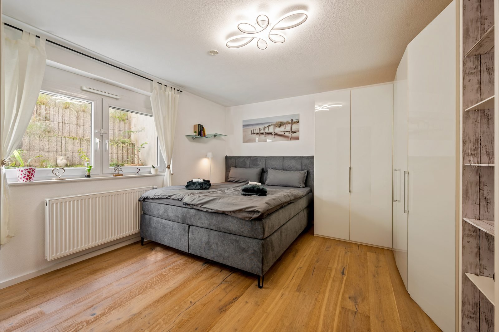 Schlafzimmer mit Boxspringbett und Eichenparkett